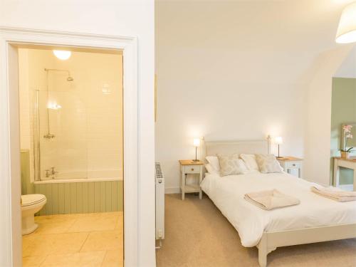 een slaapkamer met een bed en een badkamer met een bad bij 4 Bed in Coldingham CA256 in Coldingham