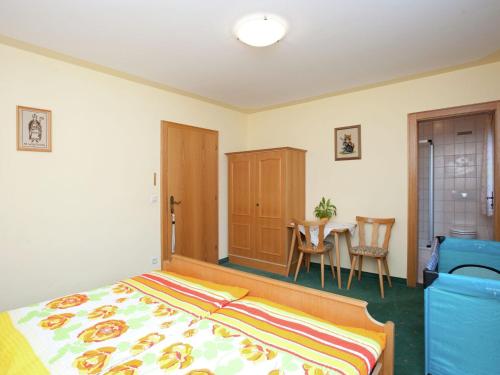 1 dormitorio con 1 cama, mesa y sillas en Apartment near the ski area in the Salzburg region, en Altenmarkt im Pongau