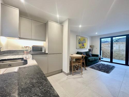 a kitchen and living room with a table and a couch at Modern 2 bedroom property with quirky décor in Chilcompton