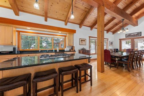 a kitchen with a counter and a dining room at Copperleaf Lodge - Updated Alpine Meadows Chalet w Private Hot Tub, Ski Shuttle! in Alpine Meadows