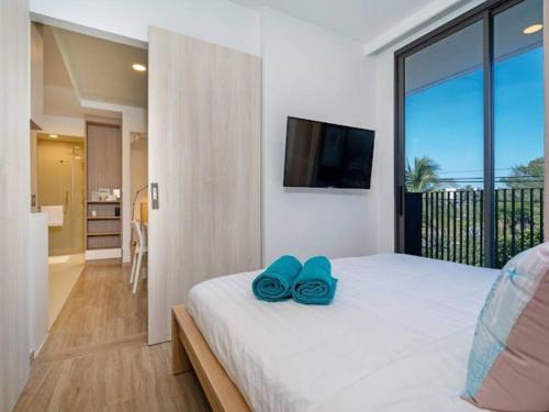 um quarto com uma cama com dois chinelos azuis em 2 спальни Апартаменты на Бангтао 600 метров от моря em Praia de Bang Tao