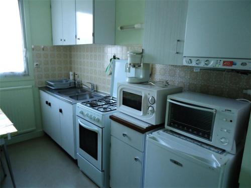 Il comprend une cuisine équipée d'appareils électroménagers blancs et d'un four micro-ondes. dans l'établissement Résidence Les Goelands - Appartement T3, a proximité de toutes commodités. MAE-6634, à Pléneuf-Val-André