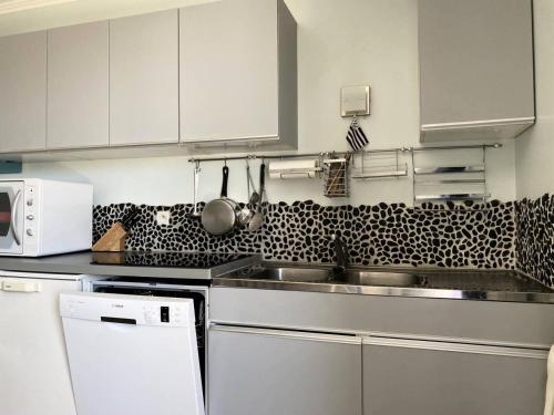 une cuisine avec un évier et un micro-ondes dans l'établissement Résidence Parc - Appartement T3 , dans une résidence à 100m de la plage, au cœur du Val André. MAE-6714, à Pléneuf-Val-André