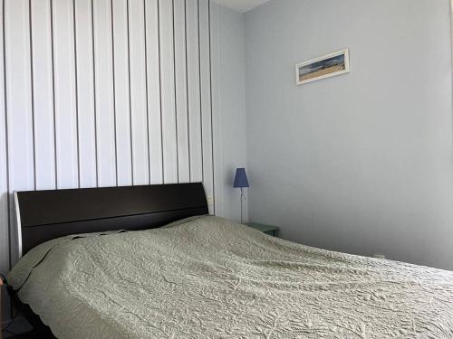 1 dormitorio con cama y pared a rayas en Résidence Parc - 3 Pièces pour 4 Personnes 714, en Pléneuf-Val-André