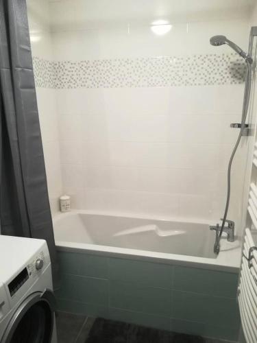 une salle de bain avec baignoire et machine à laver dans l'établissement Résidence Amiraute - Appartement de 50m², refait à neuf, dans une résidence à deux pas des plages. MAE-6724, à Pléneuf-Val-André