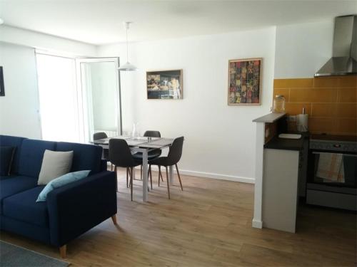un salon avec un canapé bleu et une table dans l'établissement Résidence Amiraute - Appartement de 50m², refait à neuf, dans une résidence à deux pas des plages. MAE-6724, à Pléneuf-Val-André