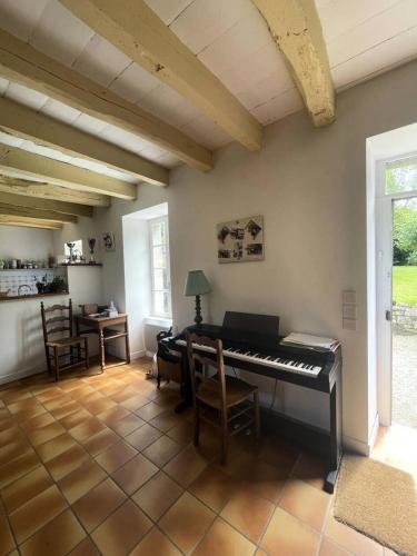 - un salon avec un piano et une table dans l'établissement Résidence 740-pleneuf Val Andre - Belle maison en pierre offrant de beaux volumes dans la campagne de Pleneuf Val André MAE-8554, à Pléneuf-Val-André