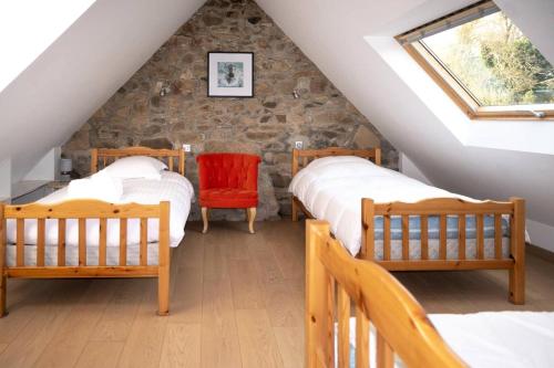 a attic bedroom with two beds and a window at Résidence Ty Gouermel-plougrescant - Maisons & Villas pour 5 Personnes 854 in Lannion