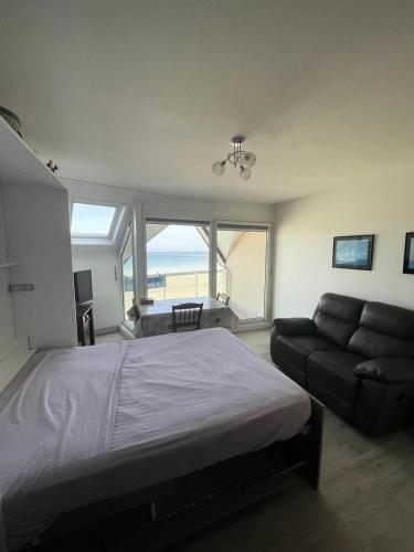 une chambre avec un lit, un canapé et une fenêtre dans l'établissement Résidence Les Bains - Charmant studio de 30m², sur l'avenue du Val-André. MAE-6504, à Pléneuf-Val-André