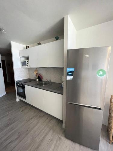 une cuisine avec un réfrigérateur en acier inoxydable et un évier dans l'établissement Résidence Les Bains - Charmant studio de 30m², sur l'avenue du Val-André. MAE-6504, à Pléneuf-Val-André