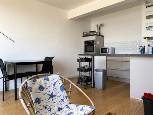 une cuisine avec une table et une chaise dans une pièce dans l'établissement Résidence Casino - Studio pour 2 Personnes 484, à Pléneuf-Val-André