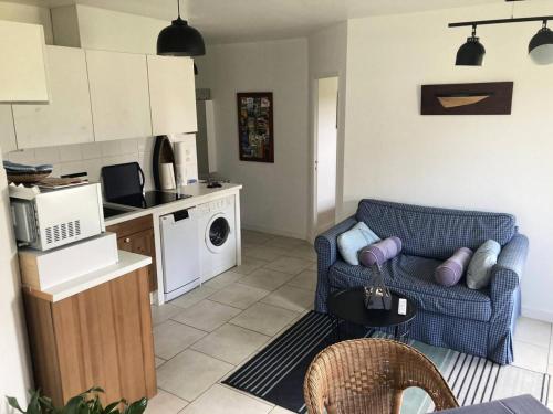 een woonkamer met een blauwe bank en een keuken bij Résidence Genets - 2 Pièces pour 2 Personnes 734 in Pléneuf-Val-André