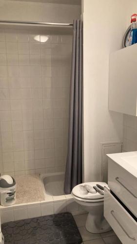 een badkamer met een douche, een toilet en een bad bij Résidence Genets - 2 Pièces pour 2 Personnes 734 in Pléneuf-Val-André