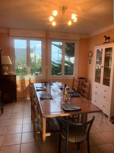 une salle à manger avec une grande table en bois avec des chaises dans l'établissement Résidence 620-pleneuf Val Andre - Belle maison néo-bretonne dans un quartier résidentiel sur les hauteurs du Val André MAE-7614, à Pléneuf-Val-André
