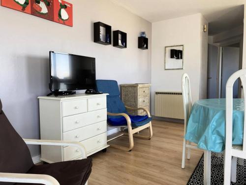 un salon avec une télévision et une chaise bleue dans l'établissement Résidence Dauphins - Appartement T2 en centre bourg du Val-André. MAE-6524, à Pléneuf-Val-André