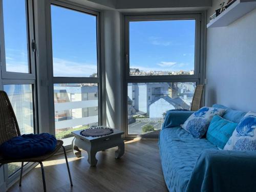 - un salon avec un canapé et de grandes fenêtres dans l'établissement Résidence Dauphins - Appartement T2 en centre bourg du Val-André. MAE-6524, à Pléneuf-Val-André