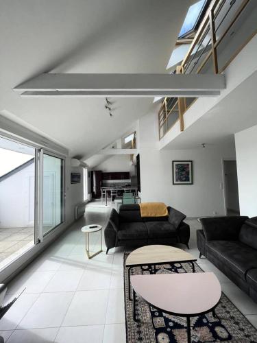 un salon avec un canapé et une table dans l'établissement Résidence Le Rocher - Appartement duplex avec vue sur les toits du val andré MAE-5384, à Pléneuf-Val-André