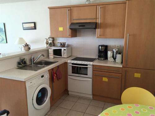 une cuisine avec un évier et une machine à laver dans l'établissement Résidence Les Bains - Charmant T3 à deux pas de la plage du Val André. MAE-6644, à Pléneuf-Val-André