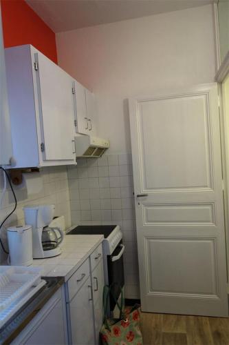 une cuisine avec des placards blancs et une porte blanche dans l'établissement Résidence 438-pleneuf Val Andre - Charmant T3 entièrement refait à neuf, à quelques mètres des plages. MAE-6654, à Pléneuf-Val-André