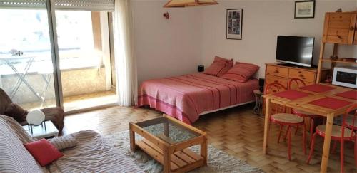 Cette petite chambre comprend un lit, une table et une télévision. dans l'établissement Résidence Maitre De Port - Studio de 35m², avec pleine vue mer sur le port de Dahouët. MAE-6754, à Pléneuf-Val-André