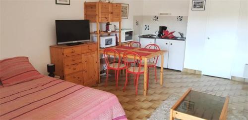 Il comprend une chambre avec un lit et une cuisine avec une table et des chaises. dans l'établissement Résidence Maitre De Port - Studio de 35m², avec pleine vue mer sur le port de Dahouët. MAE-6754, à Pléneuf-Val-André