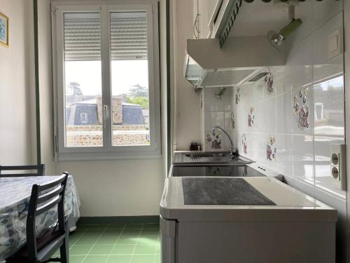 une cuisine avec un évier, une cuisinière et une fenêtre dans l'établissement Résidence Ondine - Charmant T2 de 34m² en plein cœur de la station balnéaire. MAE-2764, à Pléneuf-Val-André