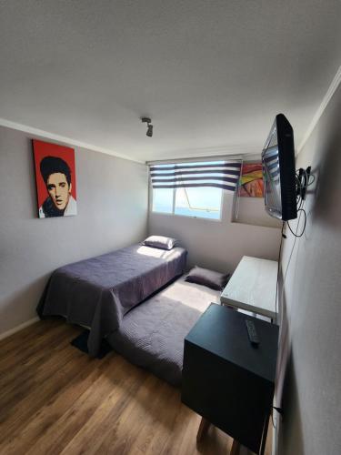 a bedroom with two beds and a television in it at Playa Huayquique, primera linea in Iquique