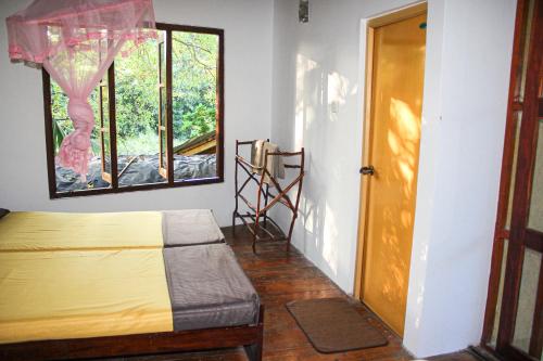 a bedroom with a bed and a window and a door at Seasons Four Eco Friendly Cabana MATARA in Matara