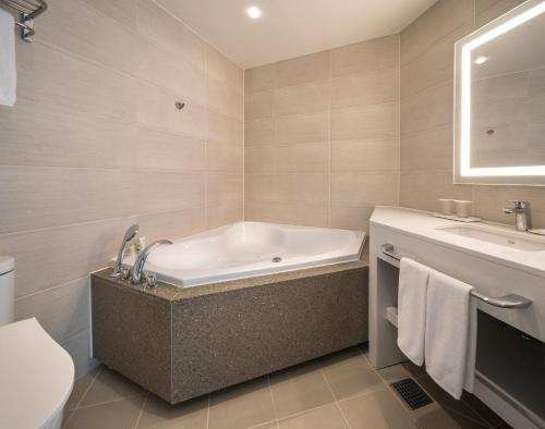 a bathroom with a tub and a sink at Grab The Ocean Songdo in Busan