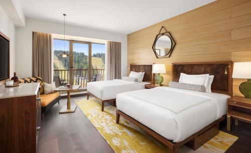 a bedroom with two beds and a living room at Viceroy Kopaonik Serbia in Kopaonik