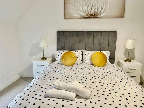 a bedroom with a large bed with yellow pillows at 2 bedrooms haven near NEC, Airport in Curdworth