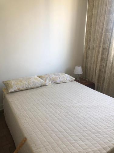 a bedroom with a bed with a pillow and a window at Quarto em apartamento in São Paulo