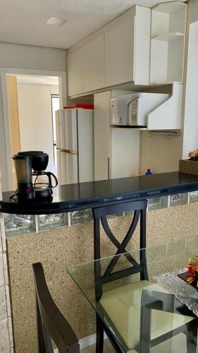 a kitchen with a table and a counter top at Flat de dois quartos Number One in São Luís