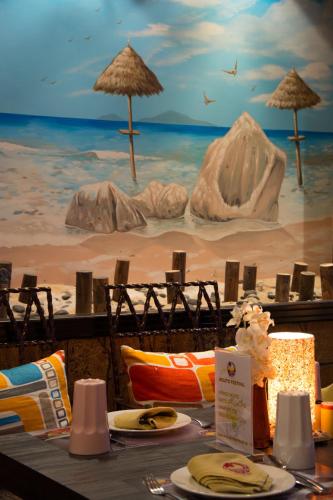 a table with chairs and a painting of a beach at Ascot Hotel in Dubai