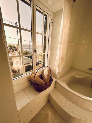 a bathroom with a window and a basket next to a tub at Casa Carneirinho by Olá Madeira in Paul do Mar