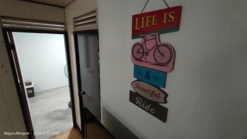a sign on a wall with a bike on it at Kochimoto Bed & Bath in Baguio