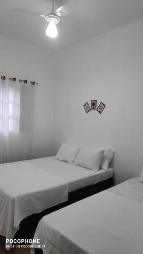 two beds sitting next to each other in a bedroom at Chácara Sombra do Altíssimo in Santa Isabel