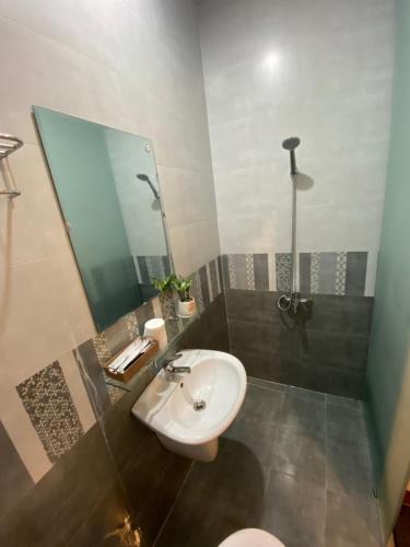 W łazience znajduje się umywalka, lustro i toaleta. w obiekcie Ju’s House w mieście Dong Hoi