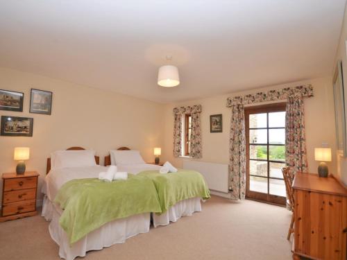 a bedroom with two beds and a window at 3 Bed in Wembury KEEPI in Wembury