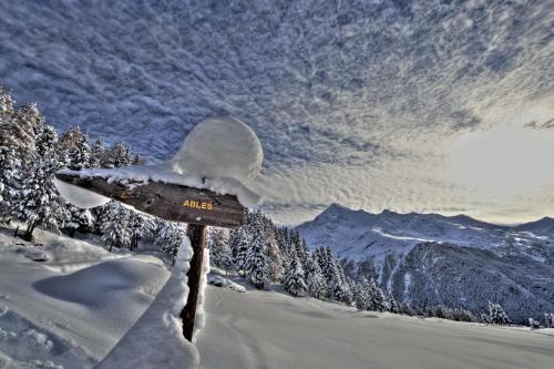 a sign in the snow with a mountain in the background at Residence Raffaella in Santa Caterina Valfurva