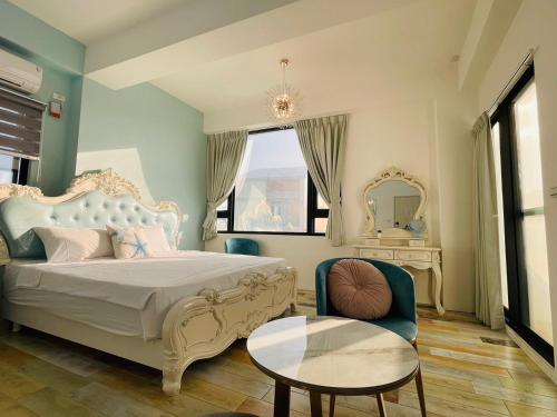 a bedroom with a bed and a table and a chair at 澎湖卡米諾民宿ll住宿接駁ll貓店長 in Magong