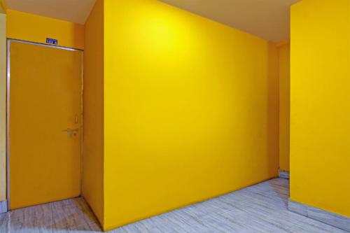 an empty room with a yellow wall at OYO Shibani & Suhani in Bārang