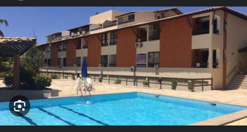 a swimming pool in front of a large building at Maresia 7B in Salvador