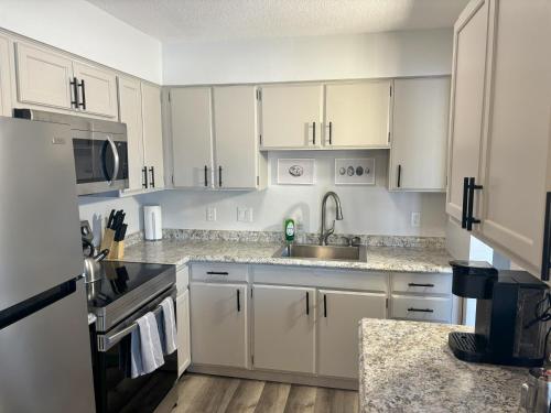 a kitchen with white cabinets and a sink at Gorgeous Remodeled Classy Family Apartment in Granite City