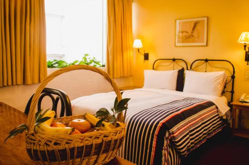 a basket of fruit on a bed in a hotel room at El Patio Miraflores in Lima