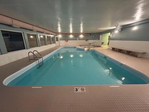 a large swimming pool in a large building at Travelodge by Wyndham Parksville in Parksville