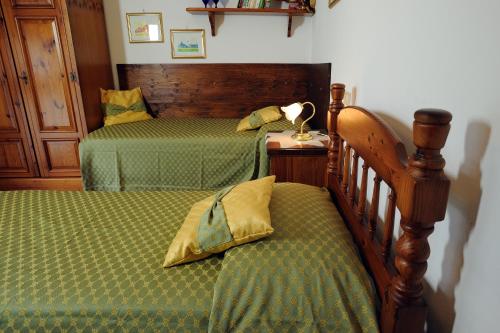 1 dormitorio con 2 camas con edredones verdes en Villa La Certosa, en Pisa