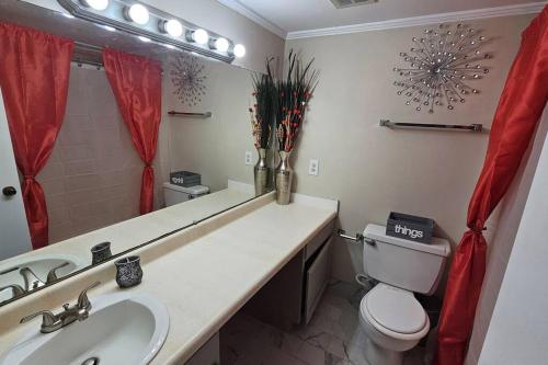 a bathroom with a sink and a toilet and a mirror at Fully Furnished Vicksburg Home Sleeps 10 in Vicksburg