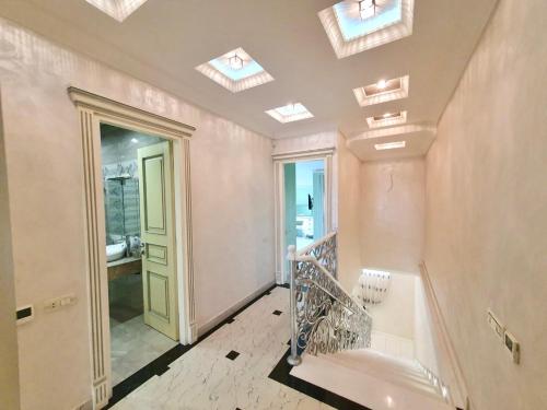 ein Badezimmer mit Oberlichtern und eine Treppe mit einem Waschbecken in der Unterkunft Роскошная двухуровневая квартира Luxurious duplex apartment in Yerevan
