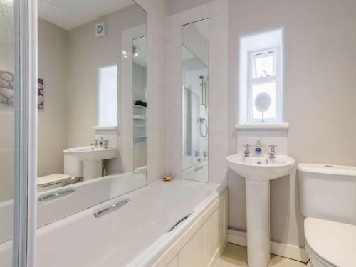 a white bathroom with a tub and a sink at 2 Bed in Bakewell PK894 in Bakewell